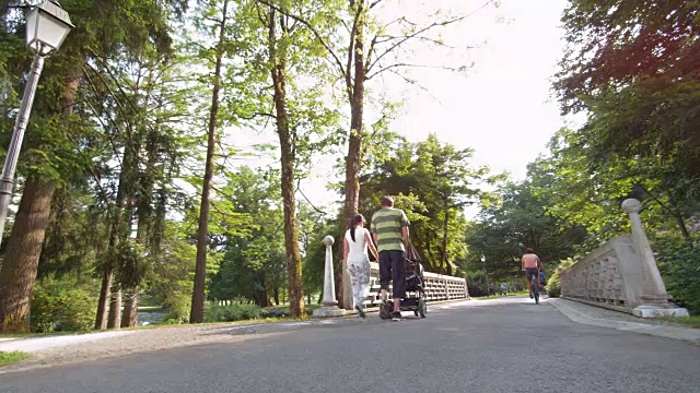 父亲和儿子慢跑过公园里的一座桥视频素材