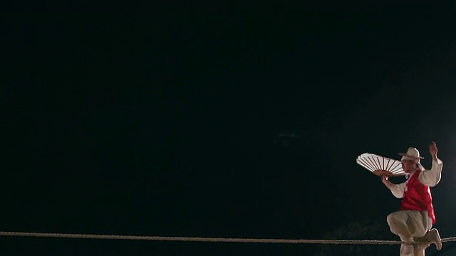 MS摄于韩国京畿道，一名走钢丝者在夜间高空钢丝上表演杂技视频素材
