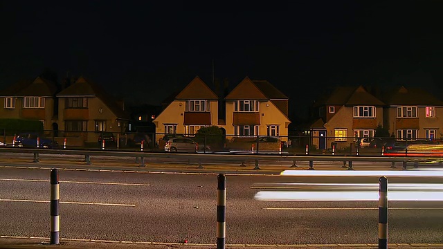 英国伦敦，高速公路上的车辆驶过一排房子视频素材