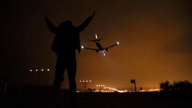 巴塞罗那机场，一个兴奋的男人注视着飞机降落的剪影。视频素材