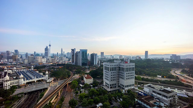 timelapse镜头美丽的吉隆坡城市的日出从一个建筑物的屋顶与移动的车辆，云和阳光爆发视频素材