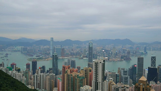 4k，俯瞰香港城市景观，俯瞰太平山顶，展现繁忙的维多利亚港和中国香港中环金融区，香港岛的天际线和一对鹰在城市上空飞翔。视频下载