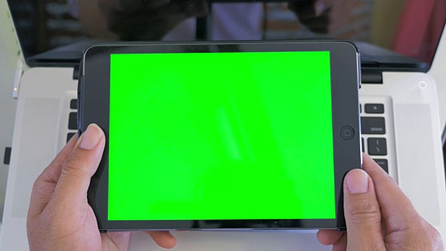 高角度拍摄的男人用数码平板电脑，绿色屏幕视频素材