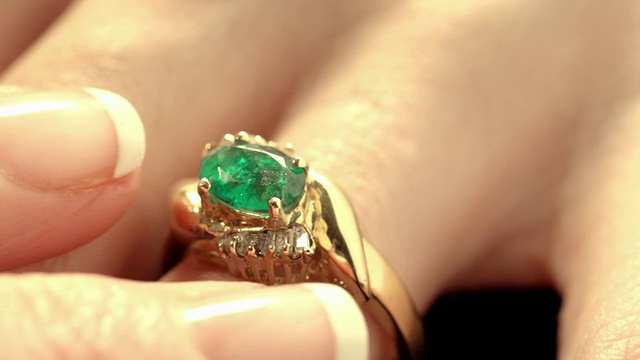 ECU绿色祖母绿宝石，在女性手上镶嵌有钻石的金戒指，手指可以调整戒指的位置。/美国加州洛杉矶视频素材