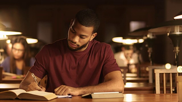 一个年轻的非裔美国人在图书馆学习视频下载