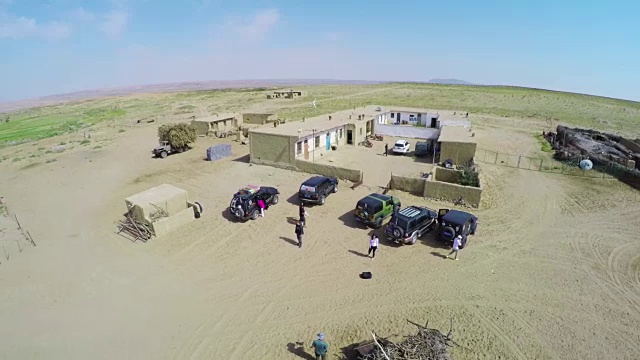 腾格里沙漠牧民家附近游客和汽车的航拍。视频素材
