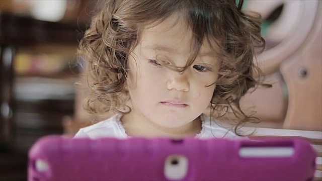 小女孩在玩电子平板电脑视频素材