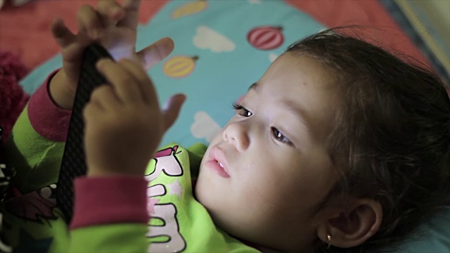 小女孩在玩数字智能手机视频素材