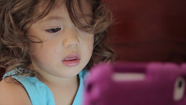 小女孩在玩电子平板电脑视频素材