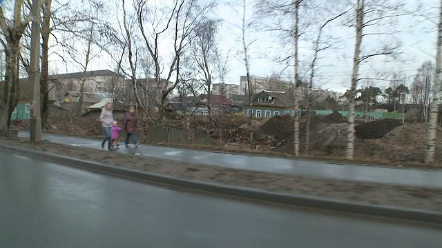 俄罗斯阿尔昌格尔斯克州的主要道路拍摄的郊区社区，色彩斑斓的腐朽房屋视频素材