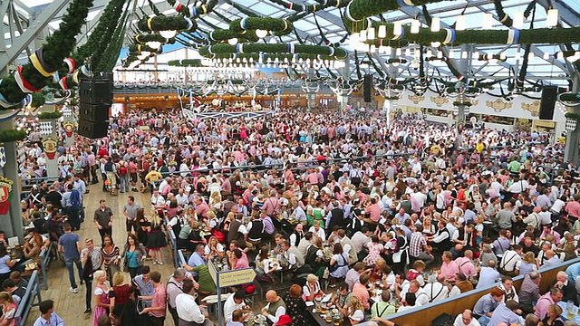 在德国巴伐利亚州慕尼黑的帐篷里，人们穿着传统服装吃着啤酒节上的食物视频素材