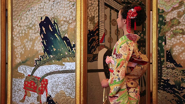 CU拍摄了一名穿着和服的日本妇女在日本折叠屏风前微笑的照片/山口，山口县，日本视频下载
