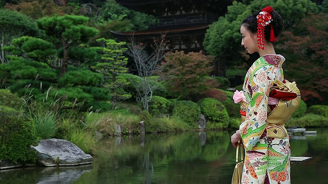 身穿和服的日本女子站在日本传统花园前的照片/山口，山口县，日本视频素材