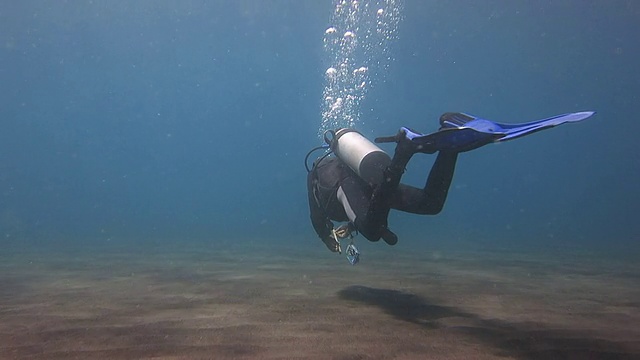 潜水员在海底的火山沙上游泳视频下载