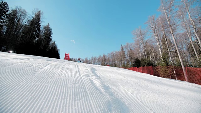 SLO MO女滑雪运动员在超级g赛跑做跳远视频素材
