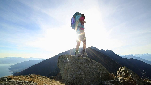 女徒步旅行者在山脊上张开双臂视频素材