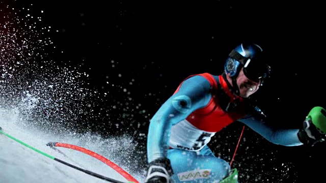 SLO MO男性滑雪选手在一场夜间回转比赛中超过一个杆位视频下载