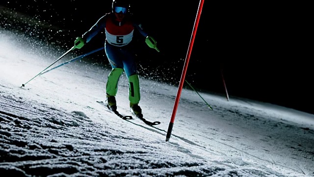 SLO MO在一场夜间回转比赛中赛道上的滑雪选手视频素材