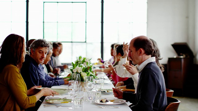 在晚宴上，微软的朋友们在餐桌上传递食物视频素材