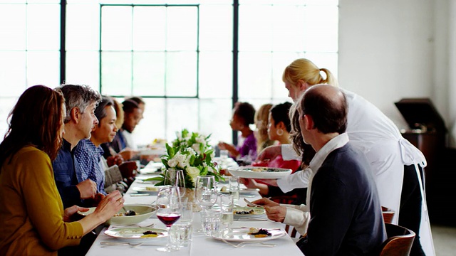 MS R/F女招待在晚宴上为朋友们带来食物和酒视频素材