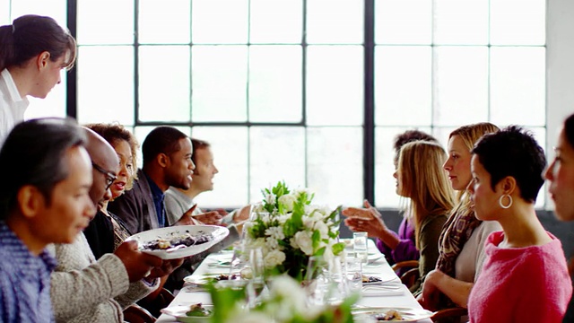 在宴会桌上，服务生为朋友端上食物和酒视频素材