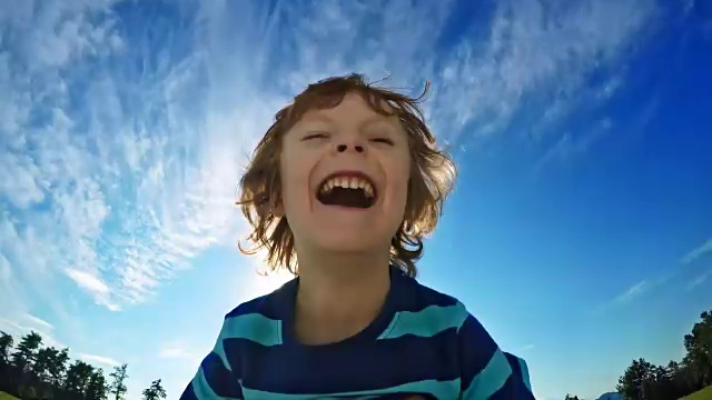 在一个阳光明媚的日子里，父亲把笑着的儿子举到空中视频素材