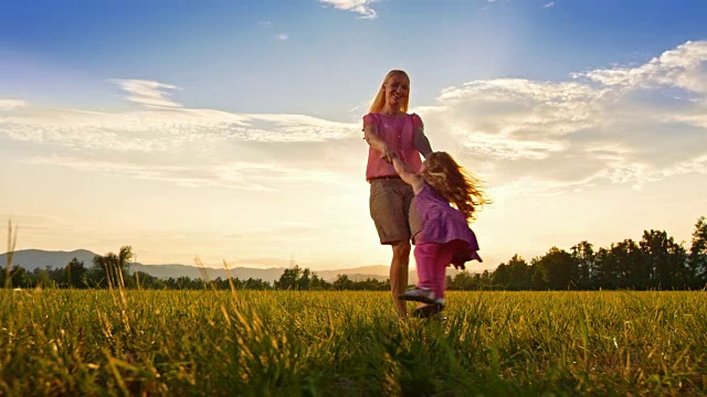 日落时分，母亲在草地上纺着女儿的纱视频素材
