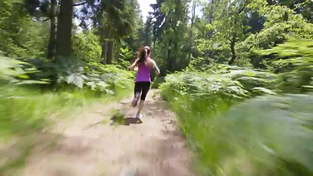 一个阳光明媚的日子，一个女人在森林里奔跑视频素材