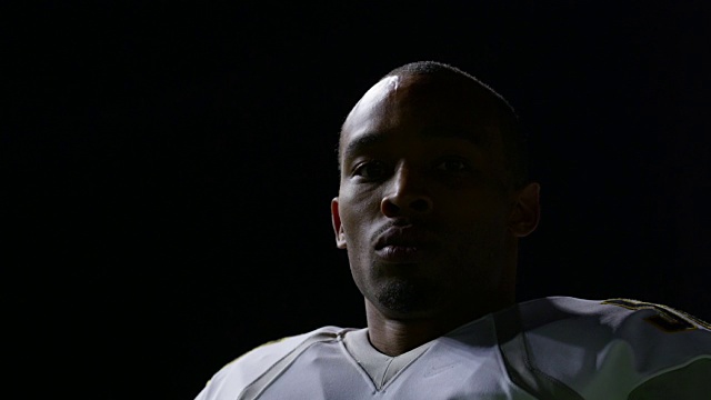 洛杉矶大学职业足球运动员戴上头盔，然后在夜间比赛中跑出球场视频素材
