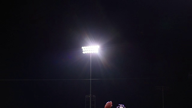 足球四分卫在晚上带着球穿过球场庆祝视频素材