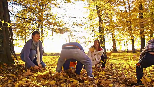 SLO MO家庭扔秋叶的乐趣视频素材