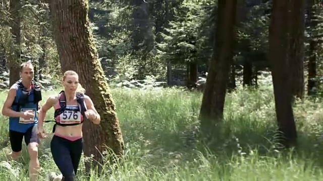 一个男人和一个女人在森林里跑马拉松视频素材