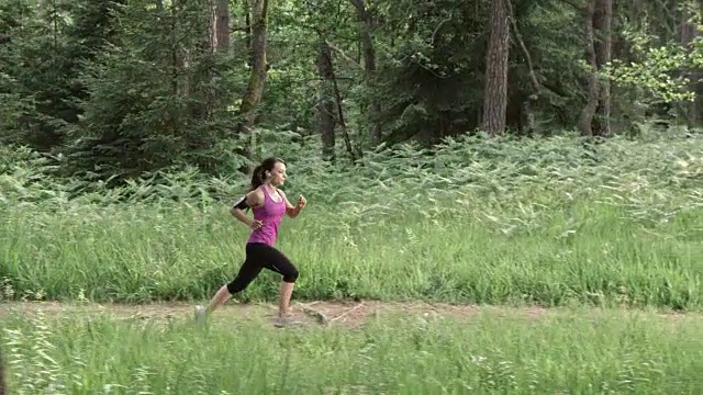 SLO MO DS女人在森林小径上奔跑视频素材