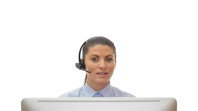 美丽的年轻女子客户服务在电脑前通过耳机在白色的背景。视频素材