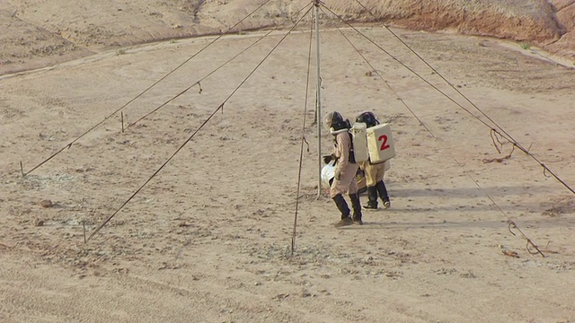 身着宇航服在美国犹他州圣拉斐尔沙漠火星沙漠研究站工作的团队成员的照片视频素材