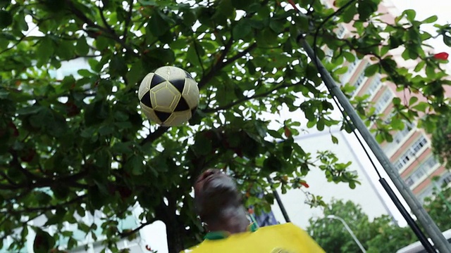 这张照片拍摄于巴西里约热内卢街头，一个有色人种男子和巴西人玩自由式足球视频下载