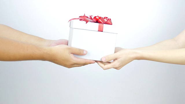 一个男人在情人节给一个女人一个礼盒。视频素材