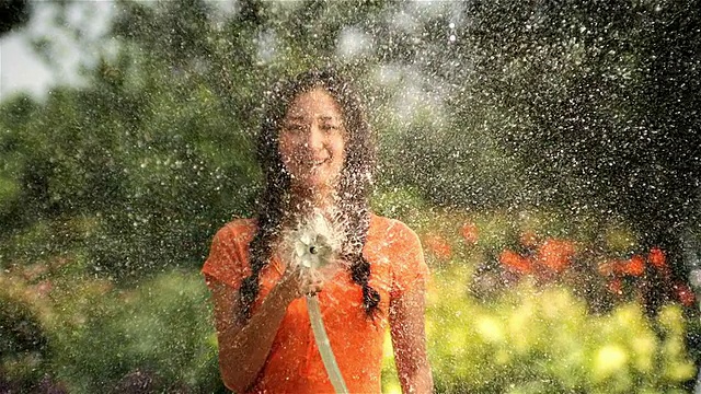 美丽的女人在花园里浇水视频下载