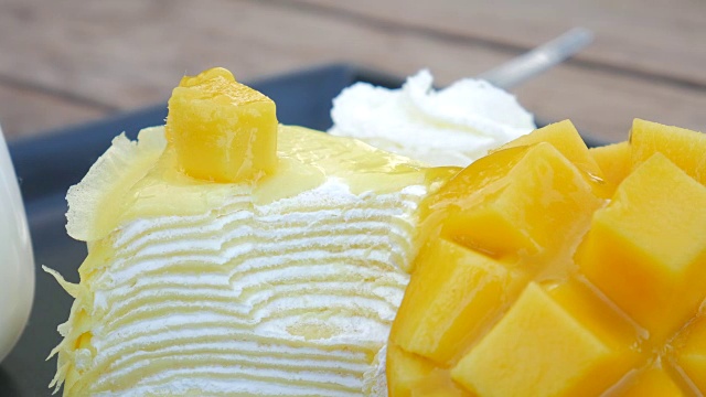 4K:芒果蛋糕在盘子里吃着芒果奶酪蛋糕，上面有新鲜的水果装饰视频下载