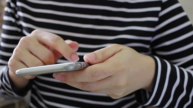 近距离的女人使用手机在办公室视频下载