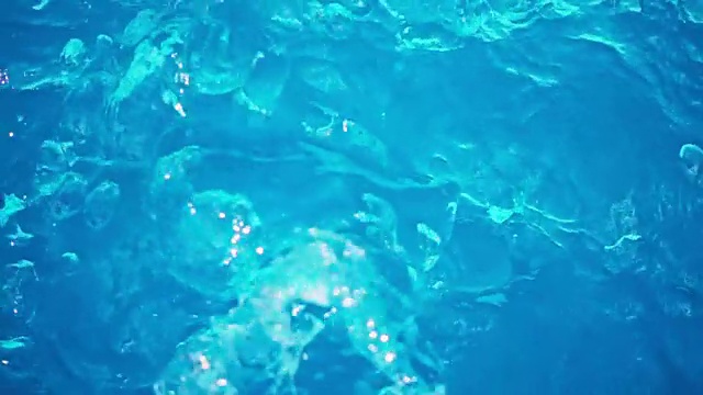 蓝色的游泳池水在缓慢地流动和溅起水花视频购买