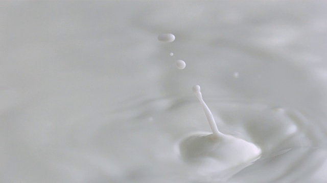 牛奶滴在移动的牛奶表面视频素材
