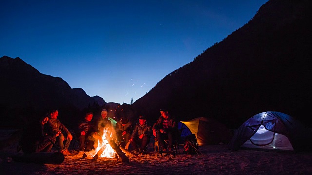 一群朋友围坐在篝火旁，交换着故事视频下载
