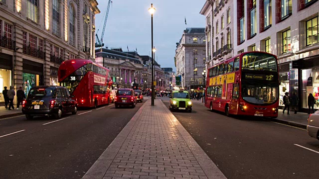在伦敦市中心皮卡迪利广场附近的皮卡迪利大街上，从交通分隔线拍摄的黄昏时段的交通流量视频素材