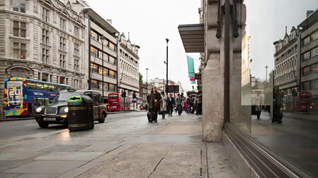 皮卡迪利大街上的行人在下午的时间流逝，标志性的伦敦车辆反映在商店的橱窗里视频素材