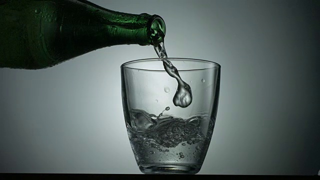 往玻璃杯里倒水的玻璃瓶视频素材