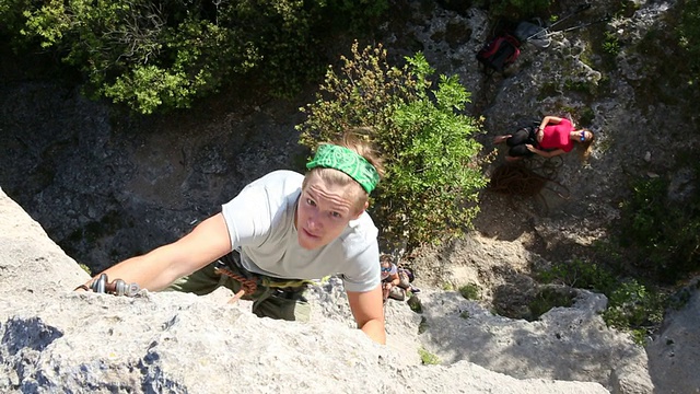 年轻人爬陡峭的岩壁超过保护者视频素材
