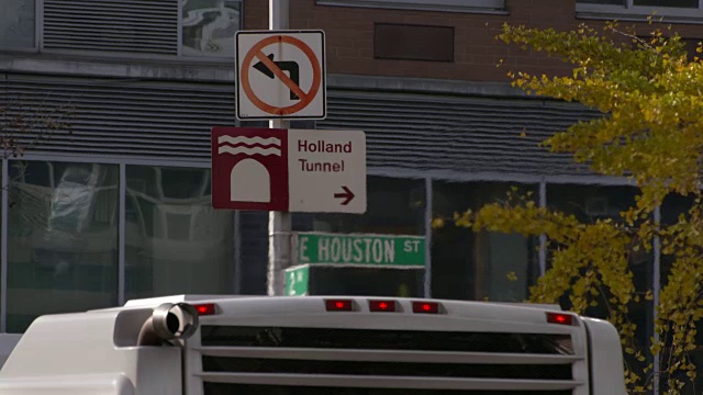 一辆公共汽车停在路边的指示牌旁，使图像失真。休斯顿街荷兰隧道视频素材