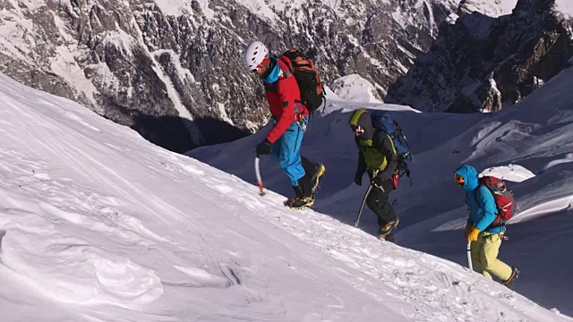 登山运动员在雪山的斜坡上行走视频素材