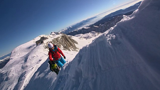 登山者们拿着冰斧爬上白雪覆盖的山坡视频素材